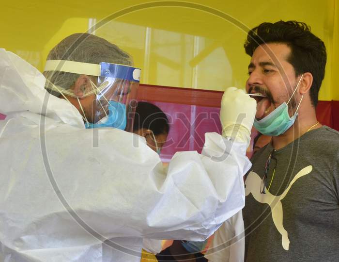 A Medic Collects Swab Sample From A Man For Covid-19 Test, At Capital State Dispensary In Guwahati, India