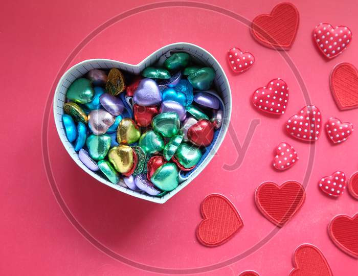 Heart Shape Gift Box With Candy On Red Background