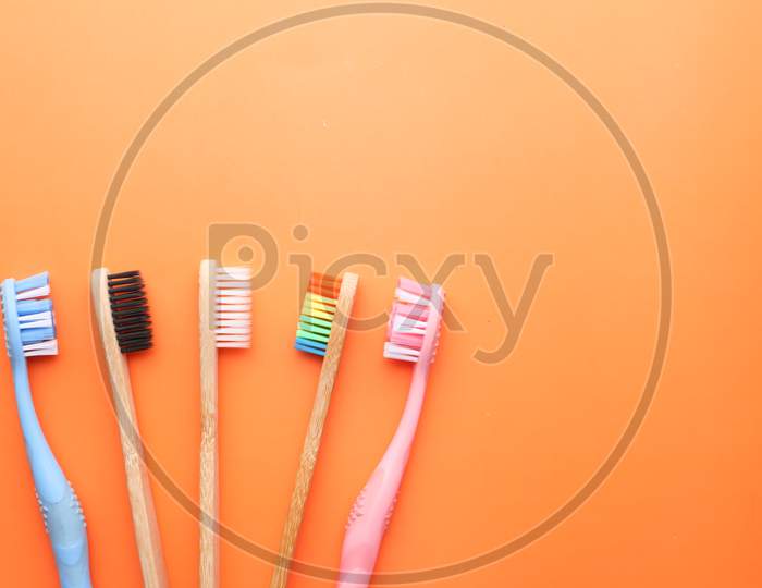 Close Up Of Colorful Tooth Brush On Orange Background.