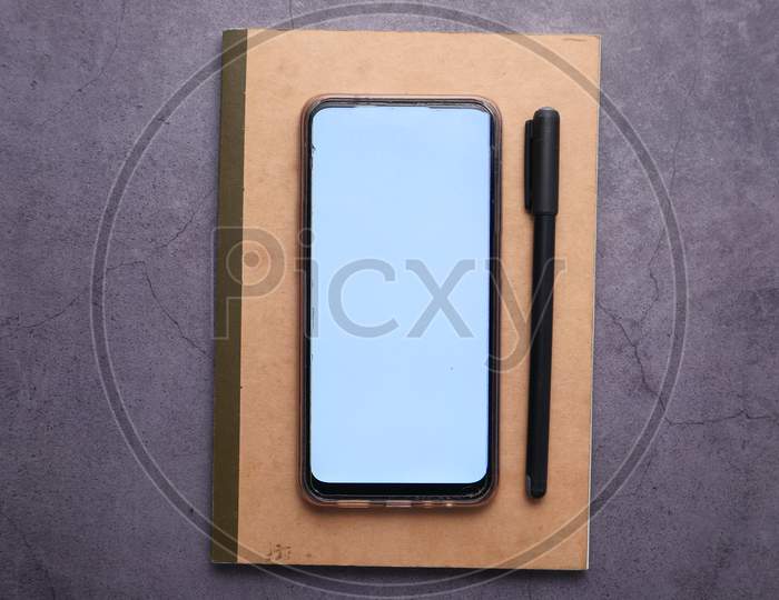 Smart Phone With Empty Screen On Notepad