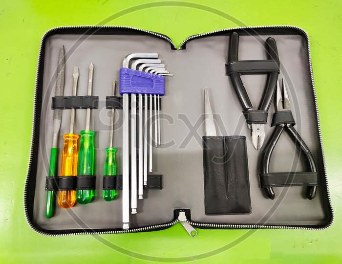 Open Tool bag with tools for Electrician and fitter on green background