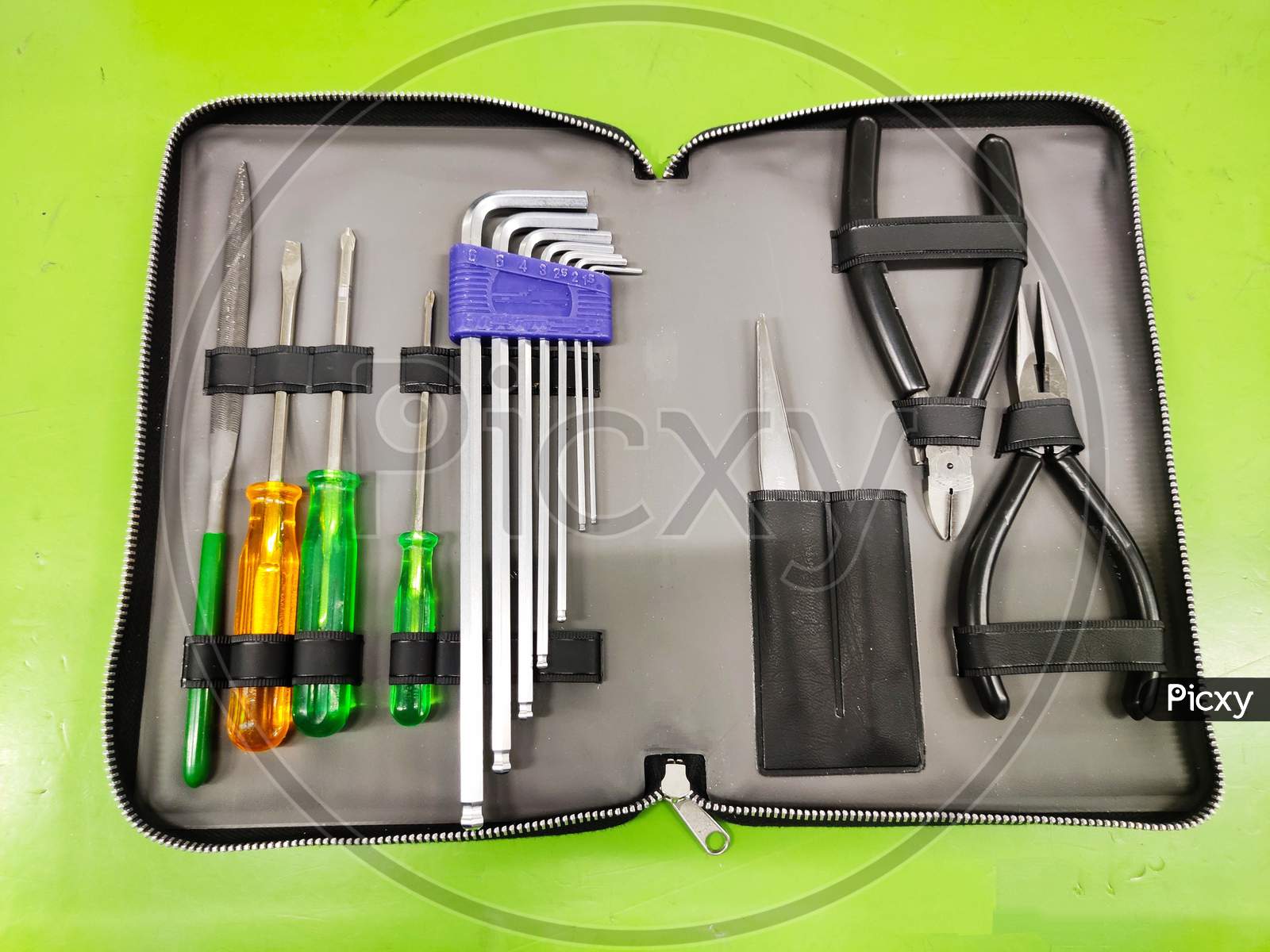Open Tool bag with tools for Electrician and fitter on green background