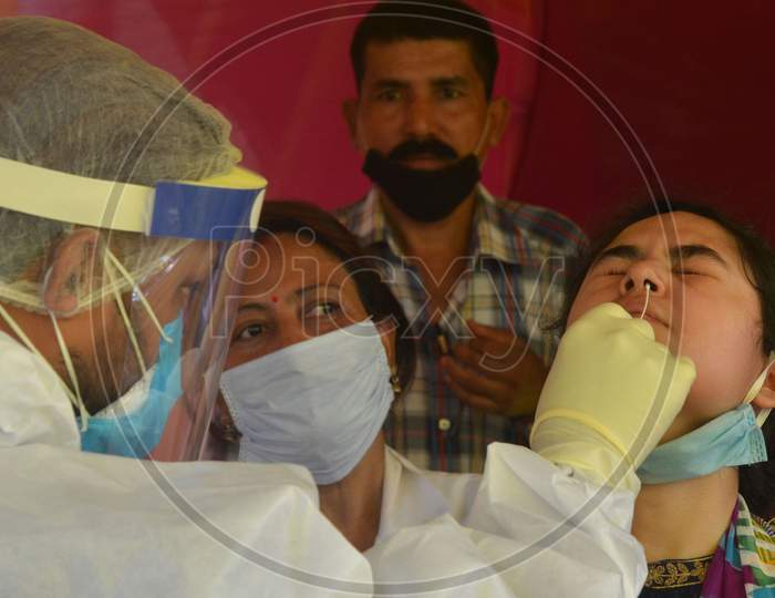 A Medic Collects Swab Sample From A Woman For Covid-19 Test, At Capital State Dispensary In Guwahati, India