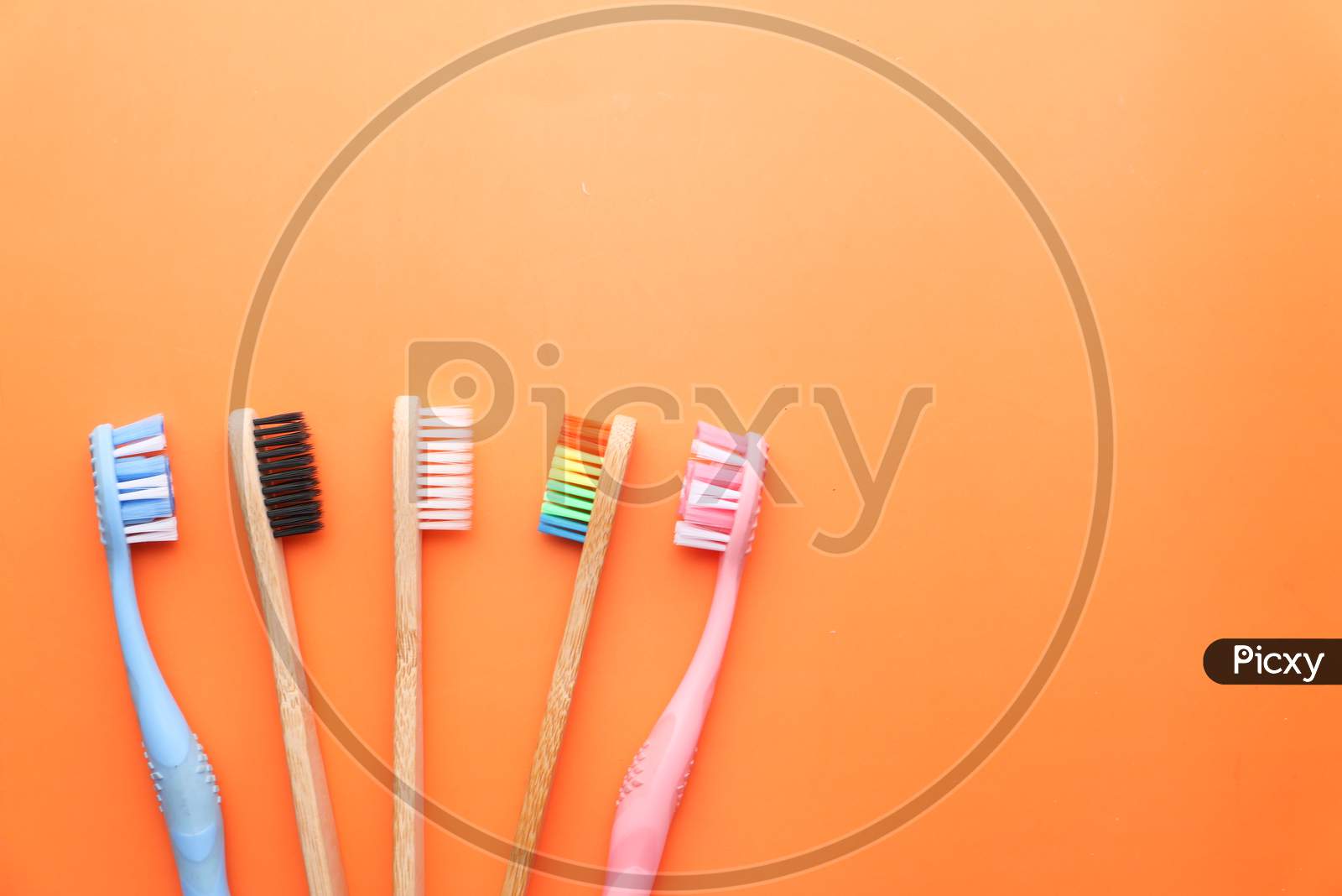 Close Up Of Colorful Tooth Brush On Orange Background.