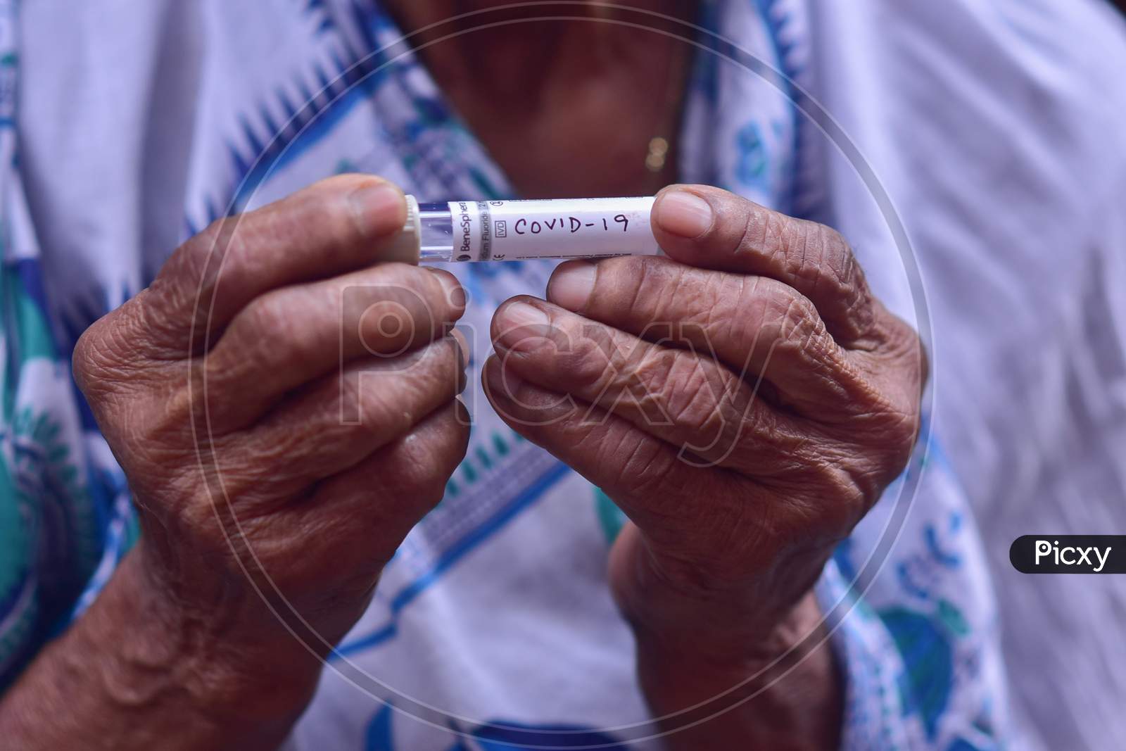 An old indian woman holding a testing kit of coronavirus of her hand