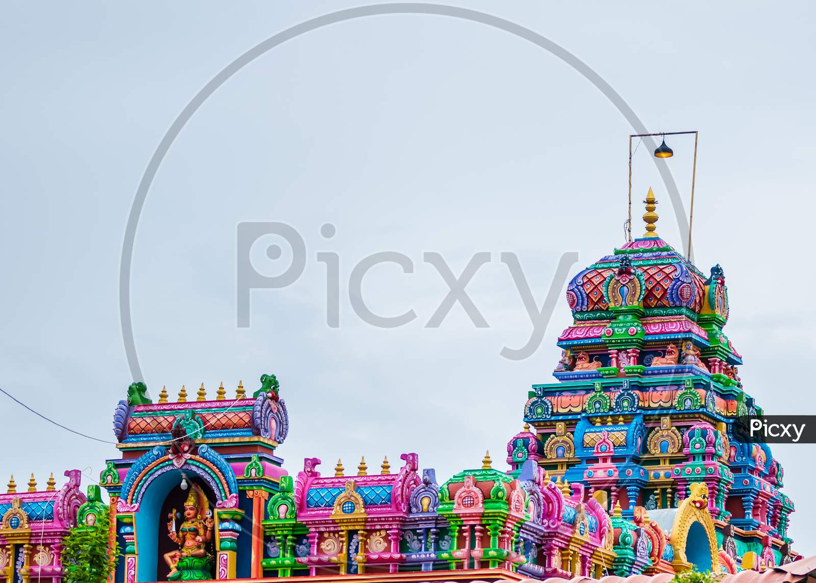A Hindu Temple With Vibrant And Colorful Sculptures Captured On A Cloudy Overcast Day