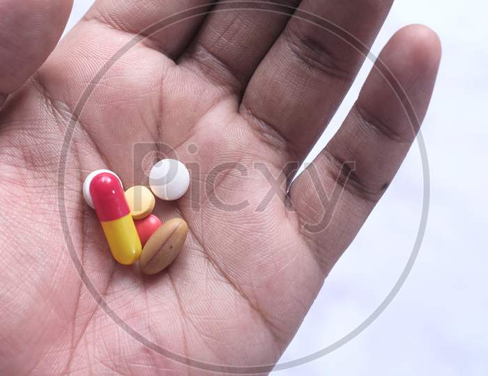 Close Up Of Pills And Capsule On Palm Of Hand