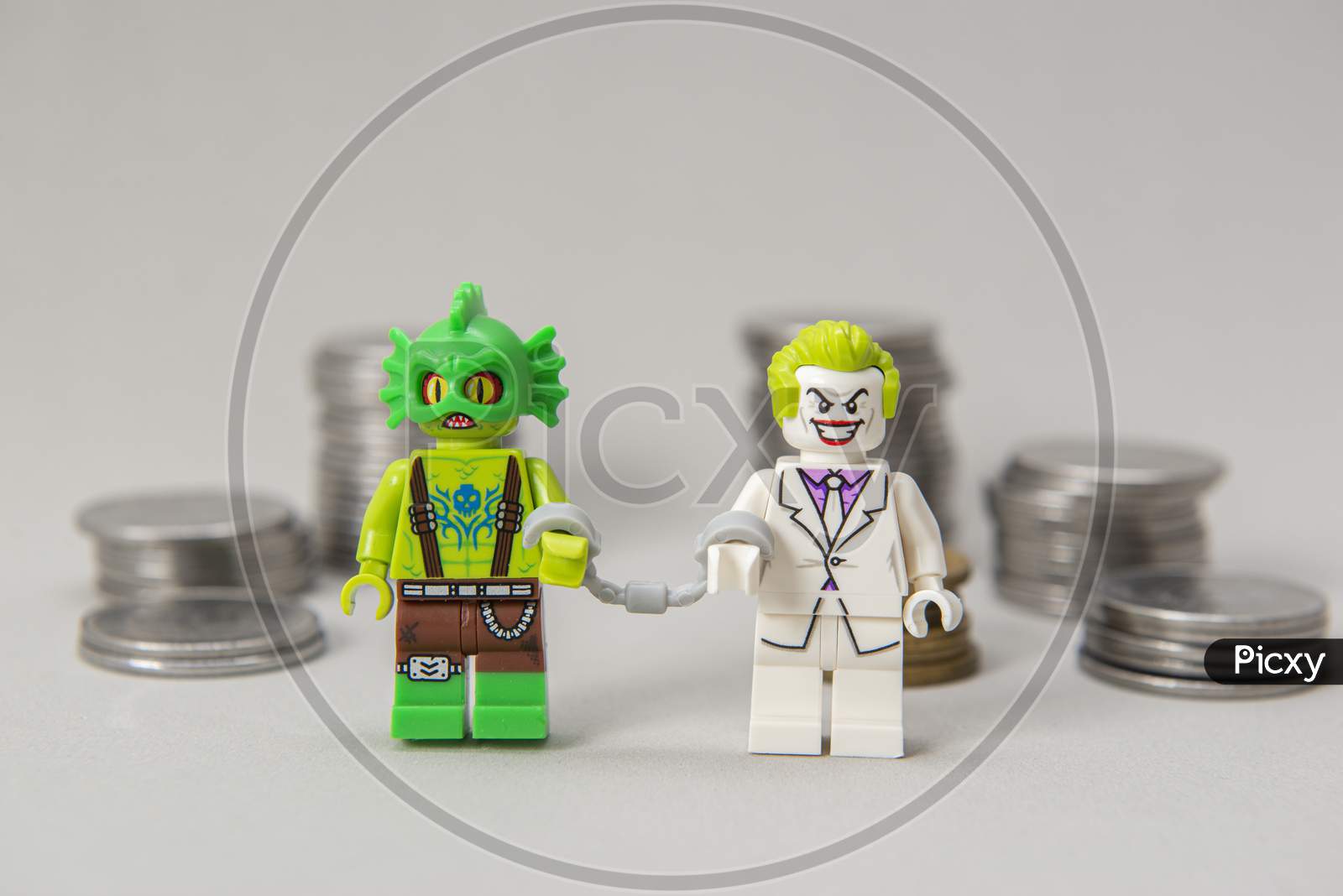 Joker And Monster Minifigure Handcuffed To Each Other With Coins.