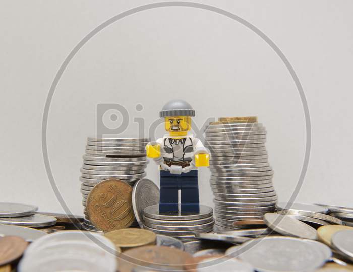 Bandit Handcuffed Next To A Pile Of Coins.