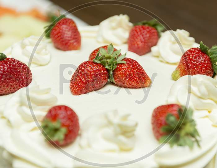 Close Up Of Creamy White Chocolate Cake With Strawberry Slices.