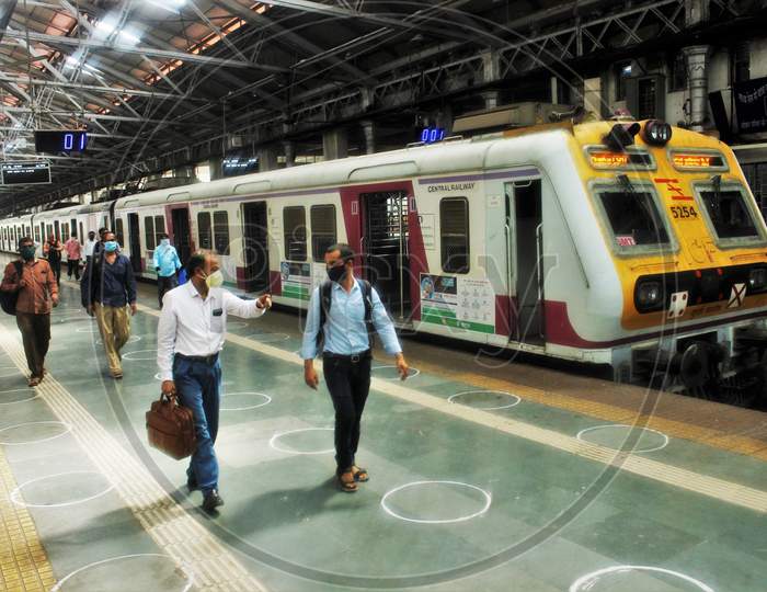 Passengers walk on a platform as they arrive with a train scheduled for essential service workers after the government eased a nationwide lockdown which was imposed as a preventive measure against the COVID-19 coronavirus, at CST local train station, in Mumbai, India, on June 15, 2020.