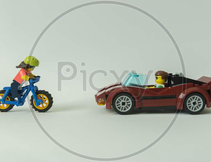 Side View Of A Red Sports Car And A Bicycle