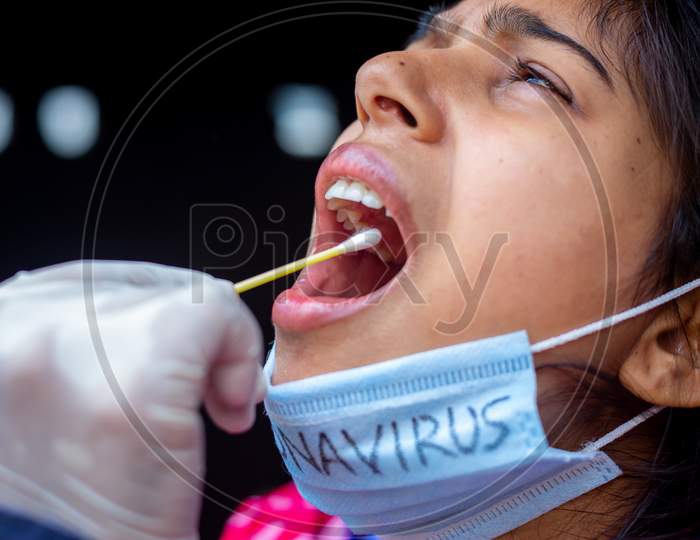 Doctor'S Hand Taking Saliva Test From Young Woman'S Mouth With Cotton Swab. Coronavirus Throat Sample Collection. Close-Up Views.