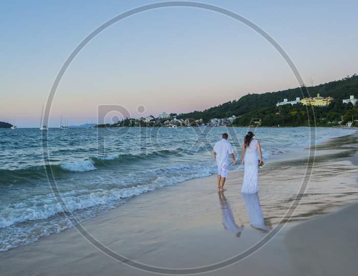 Beach Wedding With Bride And Groom Dressed In White.