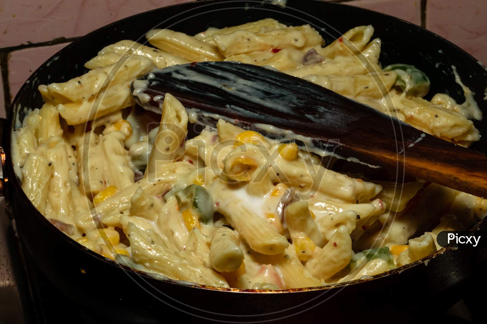 Pasta With White Sauce And Cheese Being Cooked At Home