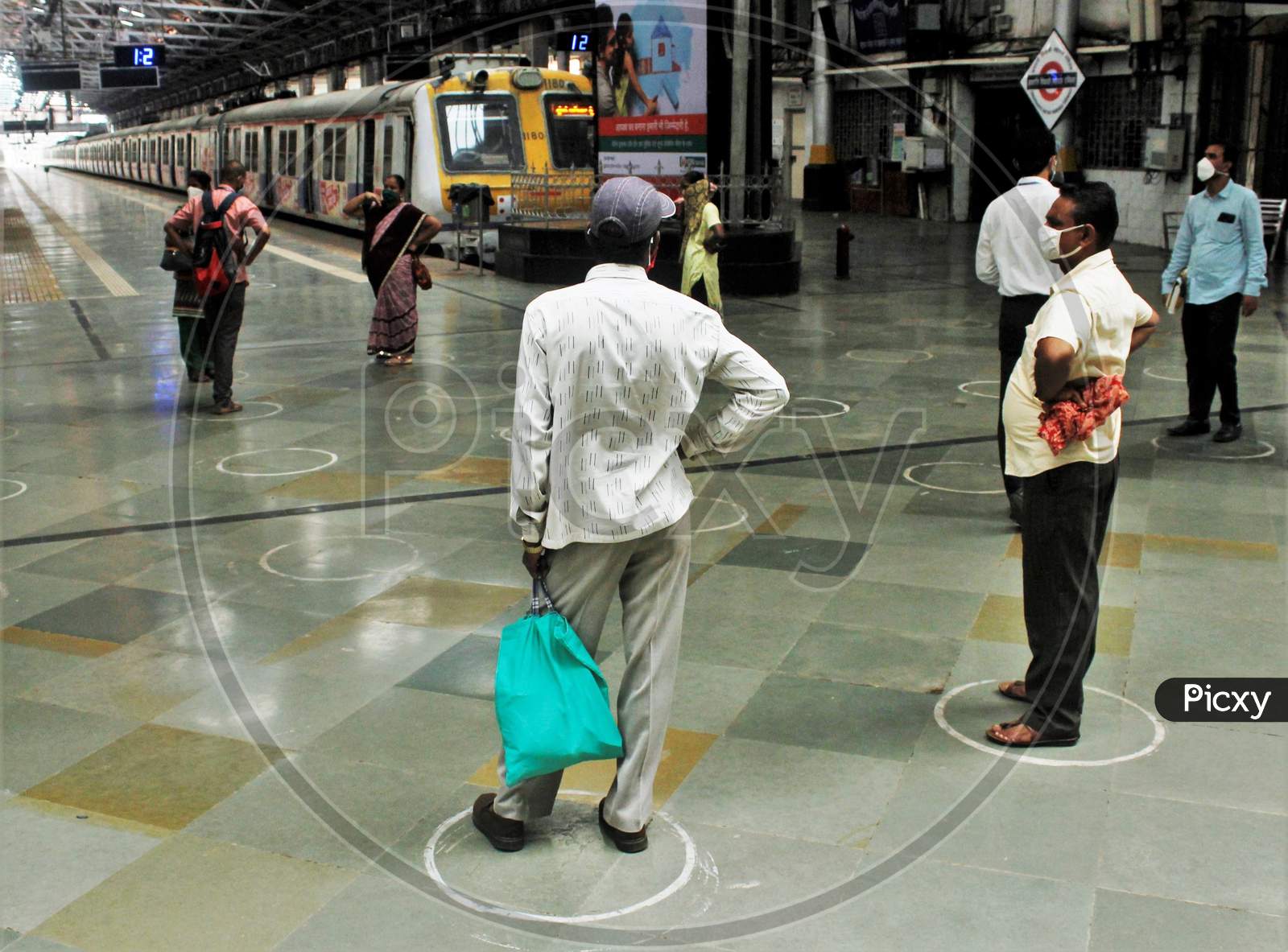 Passengers are seen maintaining distance by standing in circles painted on the platform, after the government eased a nationwide lockdown which was imposed as a preventive measure against the COVID-19 coronavirus, at the CST local train station, in Mumbai, India, on June 15, 2020.