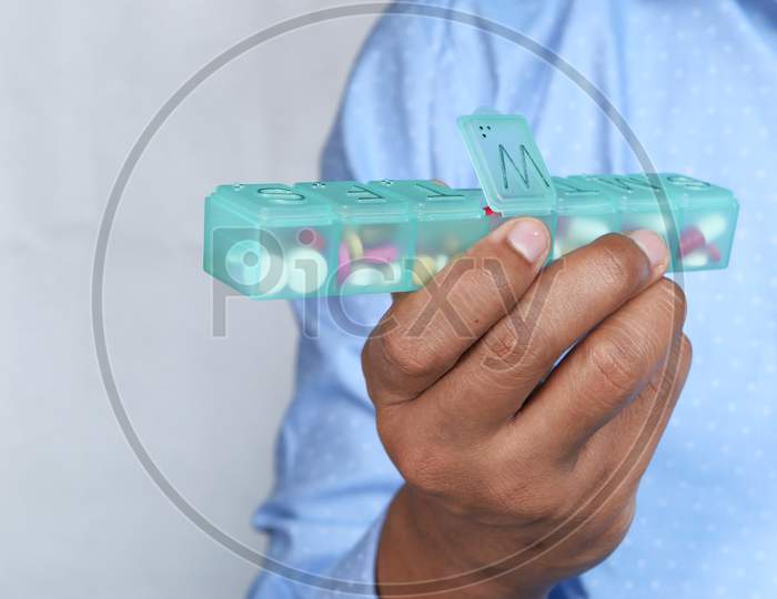 Young Man Taking Pill From Pill Box