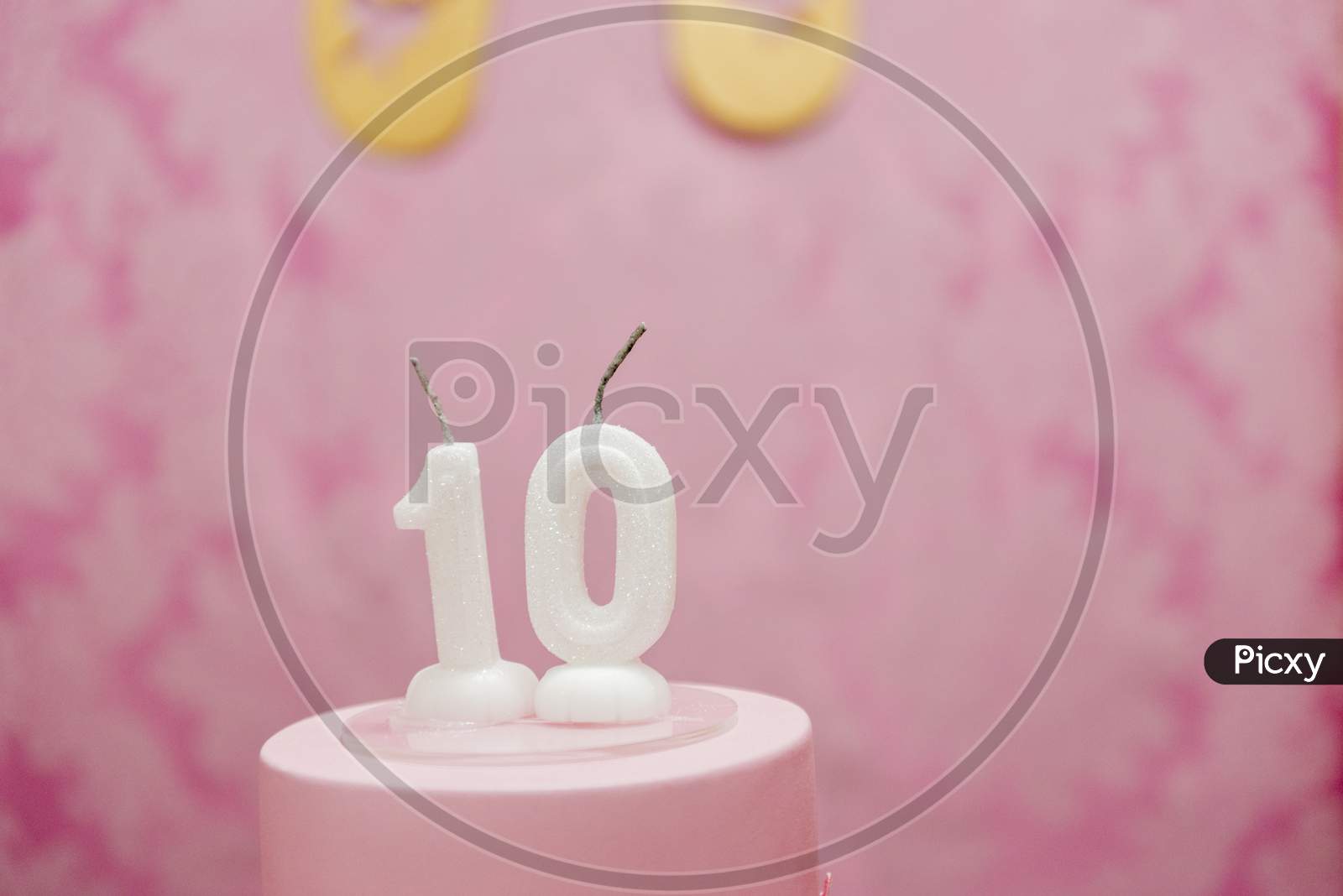 Birthday Cake With Candles As Number Ten On Pink Arabesques Background.