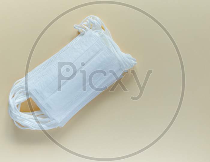 Antiviral Surgical Ear-Loop Masks For Protection Against Corona Virus. Medical Protective Masks On Yellow Background. Protection Concept