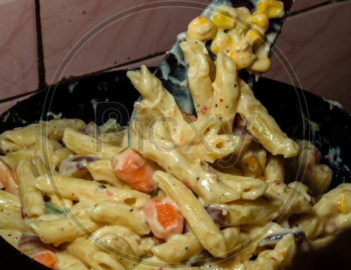 Pasta With White Sauce And Cheese Being Cooked At Home