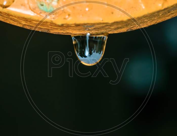 Macro Shot Of A Water Drop With Reflection After Rain Hanging From Above