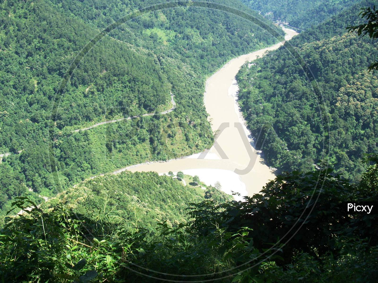 an aerial view of teesta river flowing down the valley