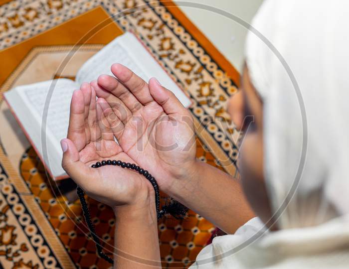 Muslim Asian Women Raise Their Hands To Pray On The Mat At Home. Indoors. Focus On Hands.