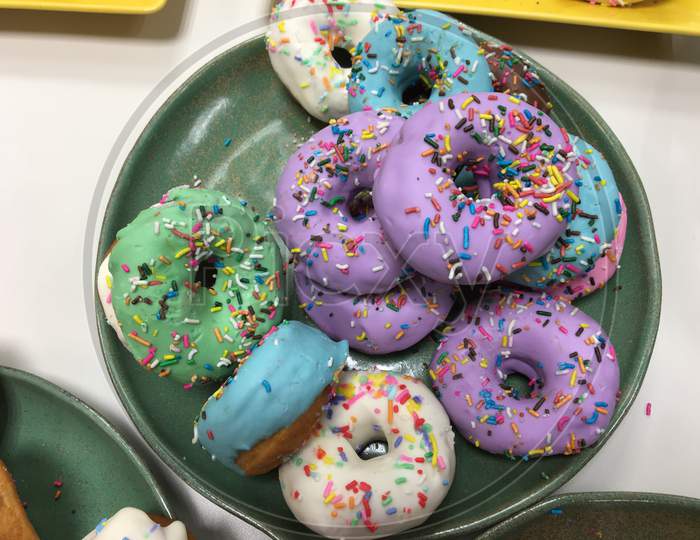 Assorted Donuts With Chocolate Frosted, Pink Glazed And Sprinkles Donuts.