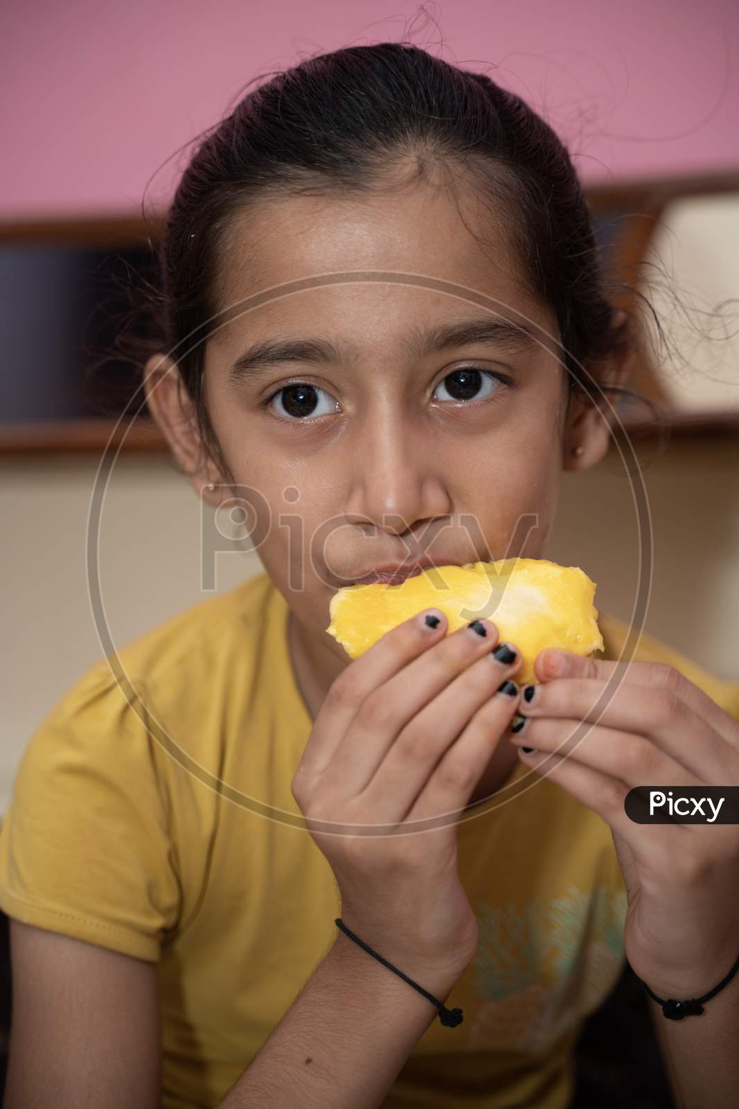 jaipur . Rajasthan . India - June 12, 2020. Happy little girl eating mango (lockdown activities)