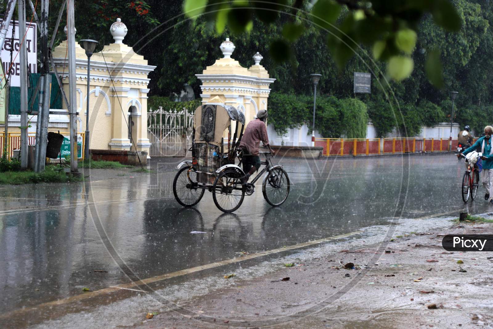 A Man Pedals his Rickshaw On The Road During a Heavy Pre Monsoon Rain In Prayagraj, June 17, 2020.