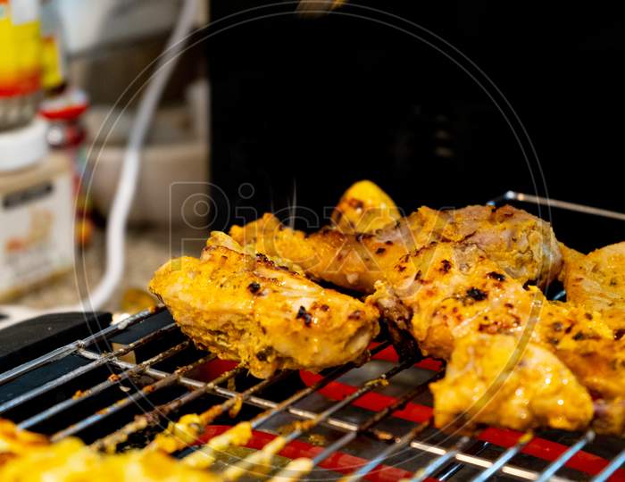 Chicken Grilling Over A Hot Electric Grill With Hot Rods At Home Barbeque