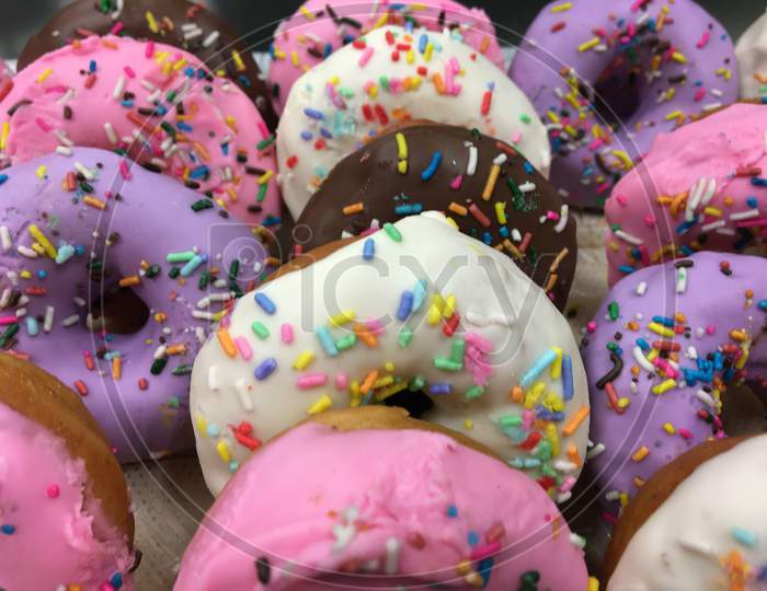 Assorted Donuts With Chocolate Frosted, Pink Glazed And Sprinkles Donuts.