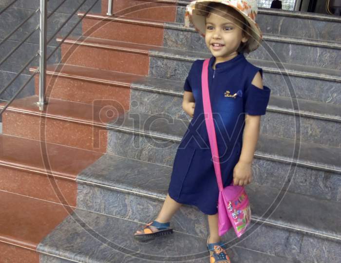 Indian child wearing cap and holding bag