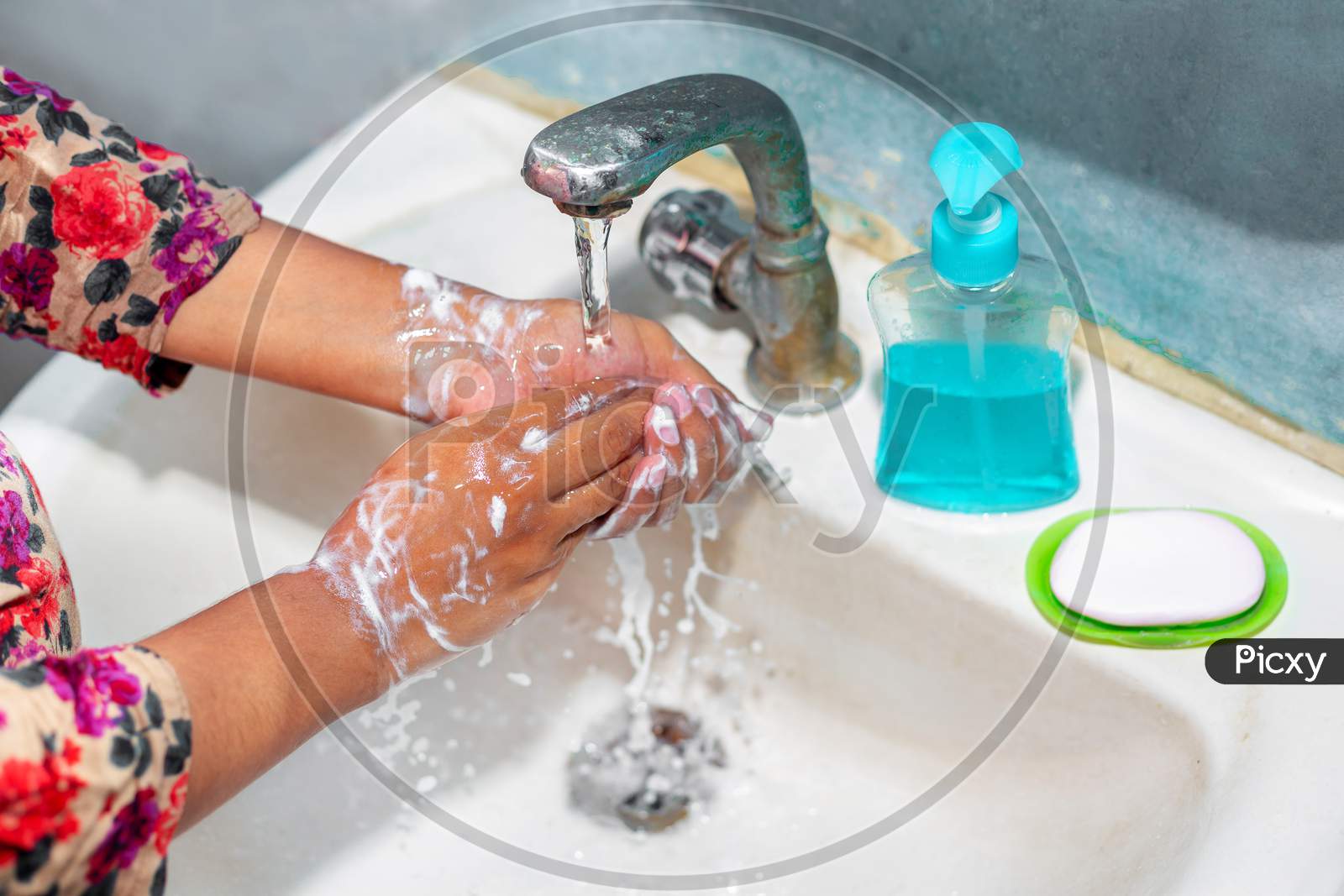 Women Use Liquid Soap For Rubbing And Washing Her Hands Under The Water Tap. Hygiene Concept. Wash Hands To Stop Spreading Coronavirus.