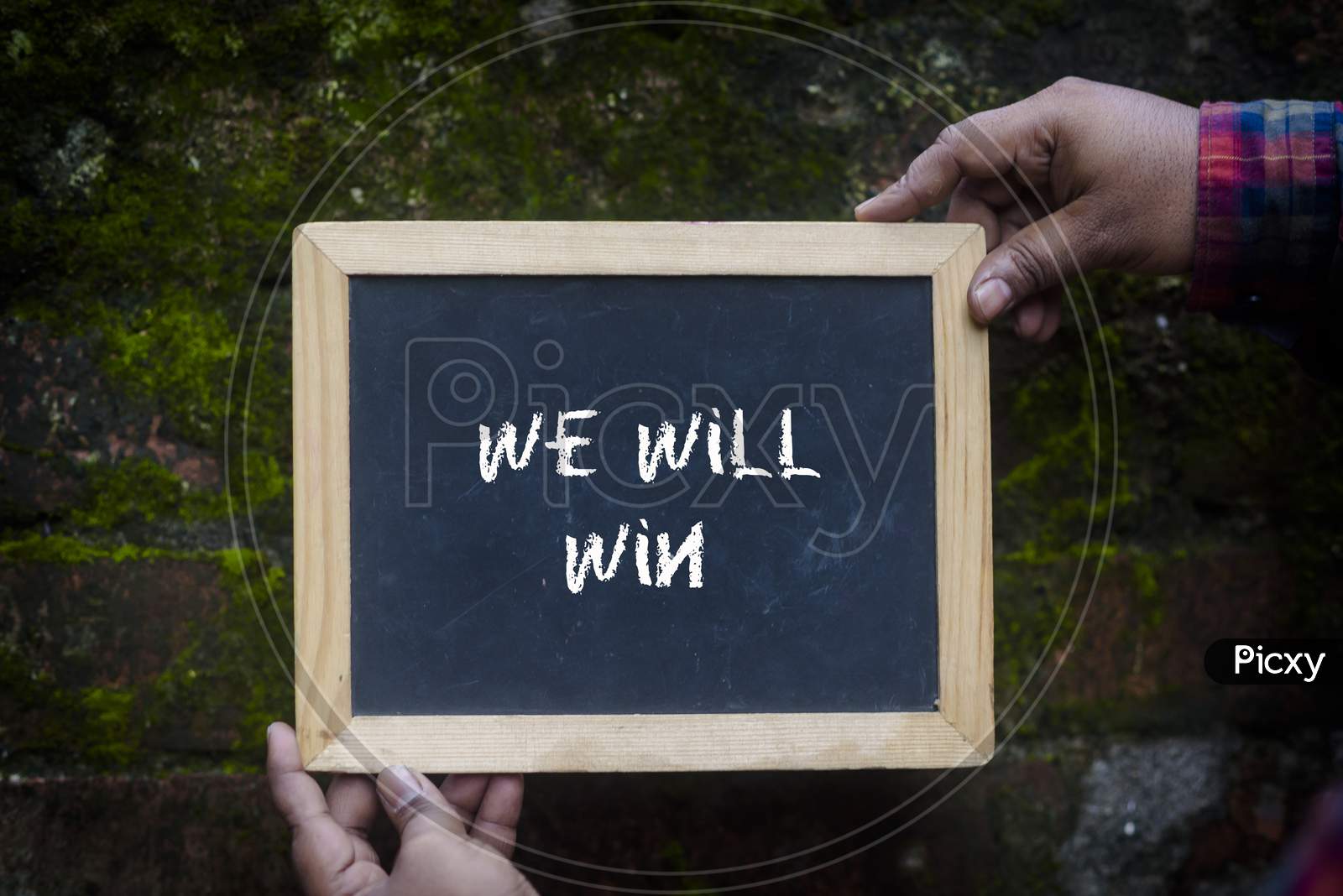 A man holding a slate with comment "We will win" to give support for coronavirus