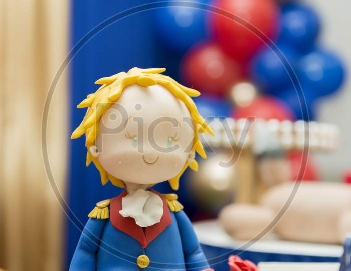 Kids Birthday Party Decoration. Little Prince Theme Party. Closeup Of Little Prince In Your Small Planet On Blue Background.