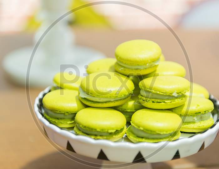 Several Lemon-Flavored Green Macaroons On A Ceramic Tray.