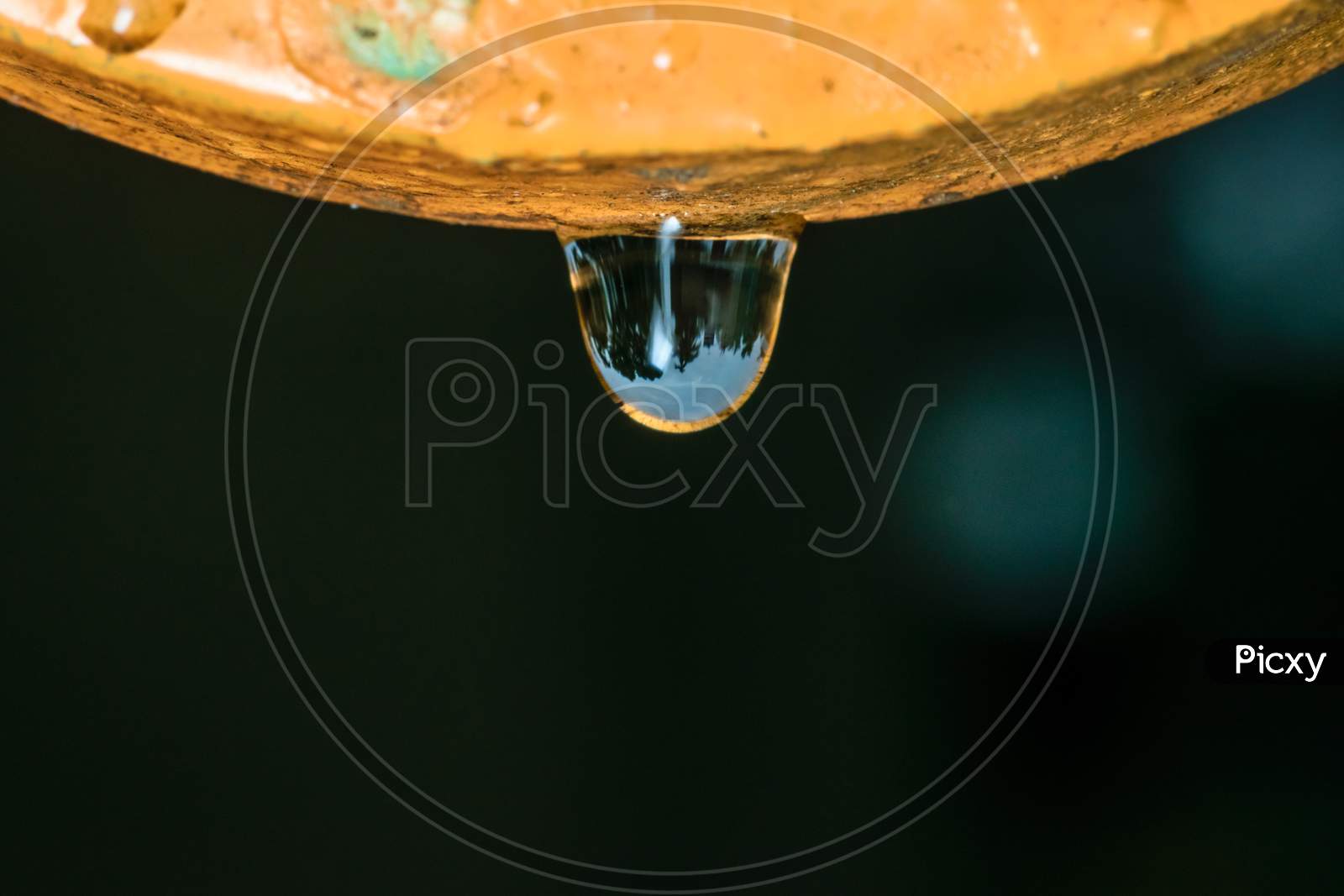 Macro Shot Of A Water Drop With Reflection After Rain Hanging From Above