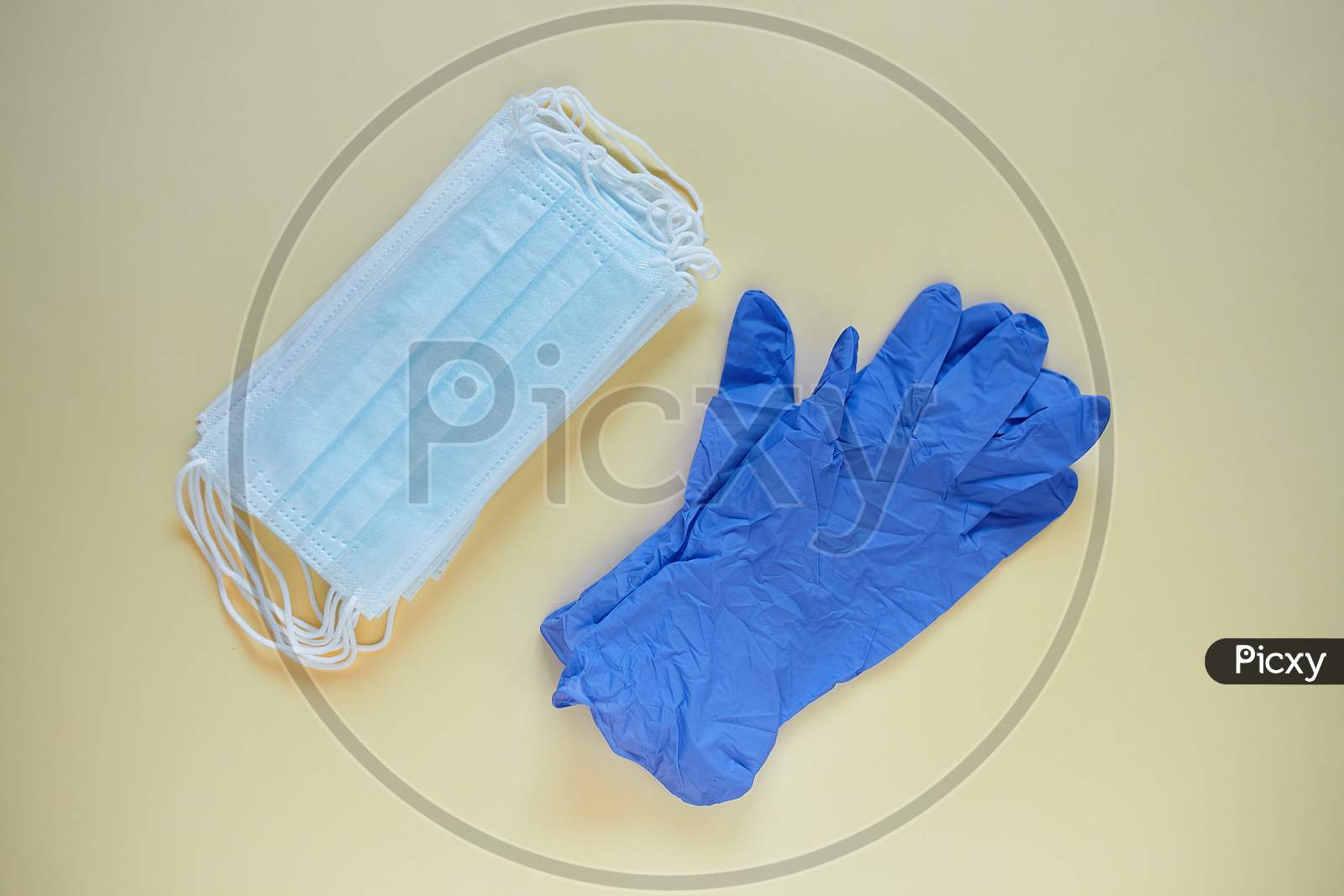 Antiviral Surgical Ear-Loop 3-Layer Masks And A Pair Of Gloves For Protection Against Corona Virus And Bacteria. Medical Protective Masks And Gloves On Yellow Background. Protection Concept