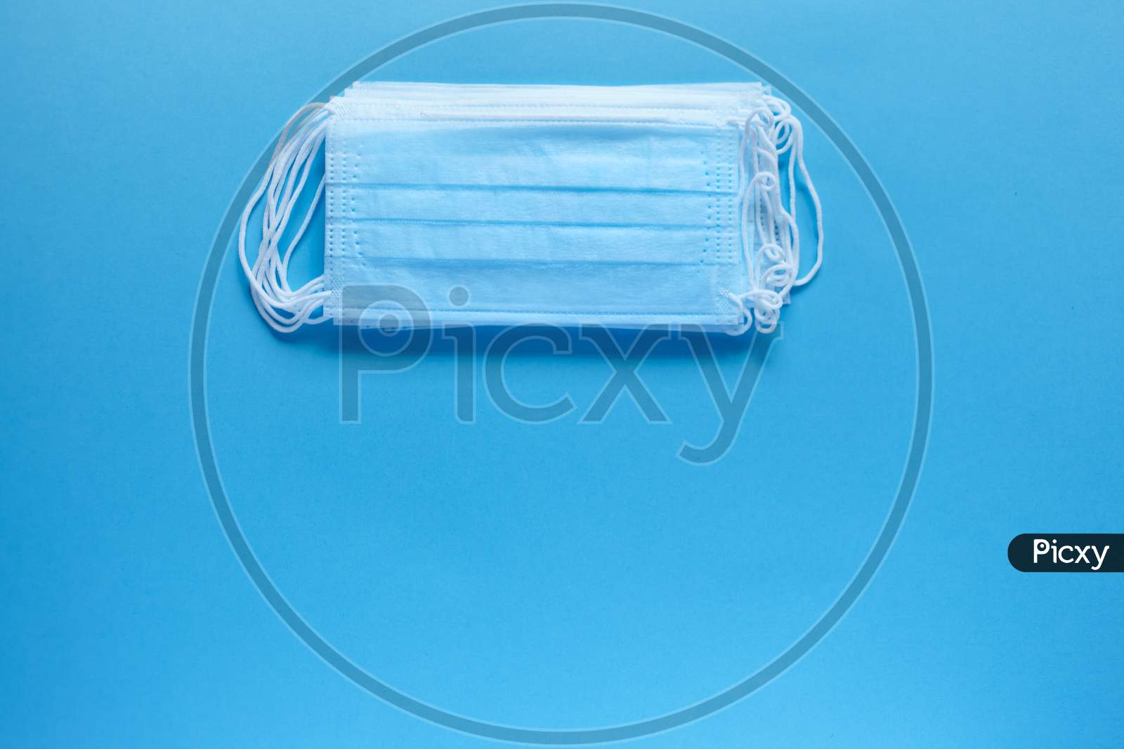 Prevent Coronavirus. Medical Protective Masks Isolated On Blue Background. Disposable Surgical Face Mask Cover Mouth And Nose. Healthcare Medical Coronavirus Quarantine. Hygiene Concept