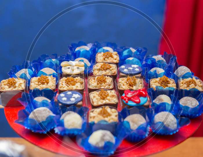 Closeup Of Decorated Chocolate Candies In A Golden Tray Decorated By Pearls. Kids Birthday Party Decoration. Little Prince Theme Party. Selective Focus.