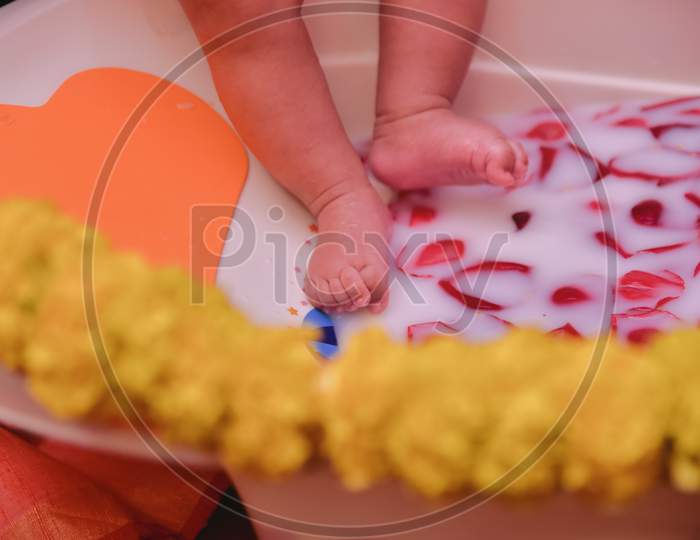 A child playing with water during her rice ceremony event in Kolkata