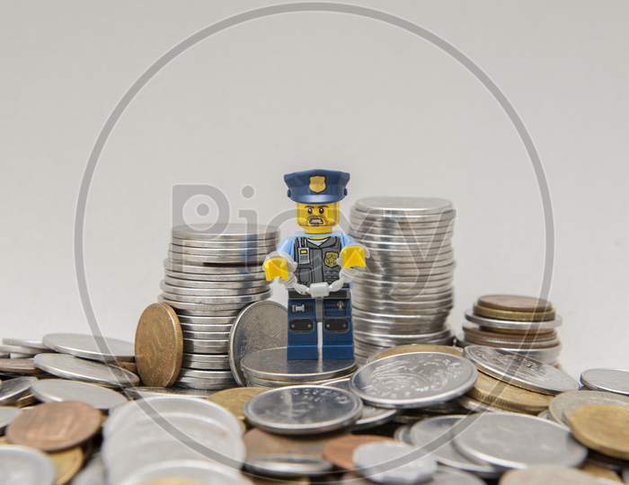 Policeman In Uniform Handcuffed By Corruption Near Coins.