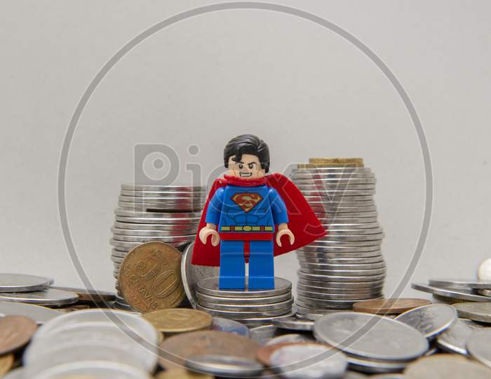 Superman On A Pile Of Silver Coins On White Background