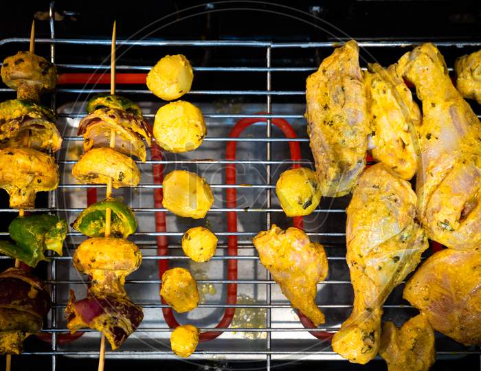 Top Flatlay View Showing Chicken Cooking On One Side And Vegetables Cooking On The Other Over A Electric Grill