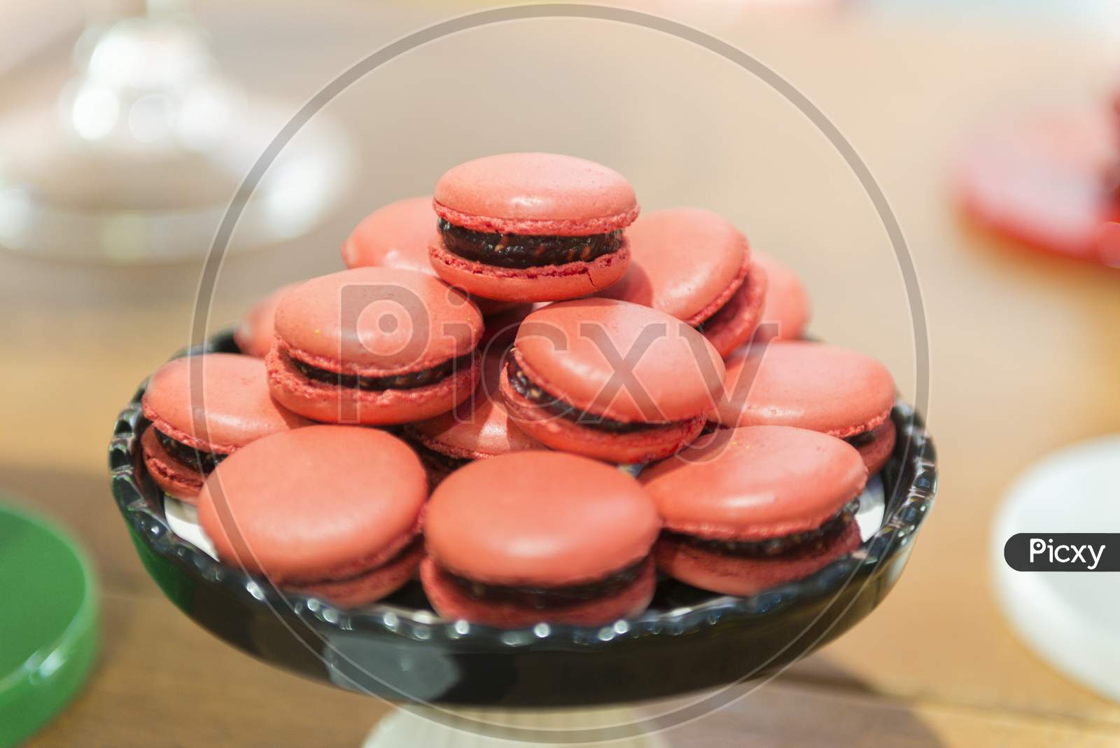 Several Red Macaroons On A Black Ceramic Tray.
