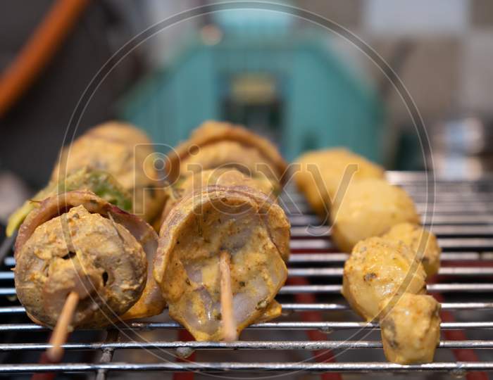 Wooden Skewer With Vegetables Like Mushroom, Chilli Pepper, Green Pepper Onions And Potatoes Cooking On An Electric Grill