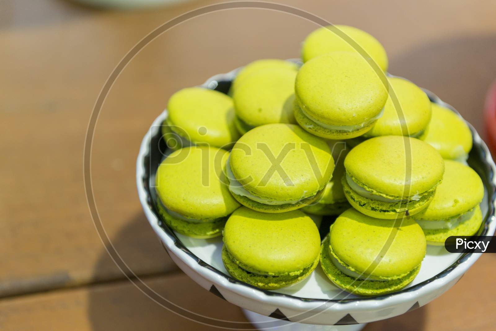 Several Lemon-Flavored Green Macaroons On A Ceramic Tray.