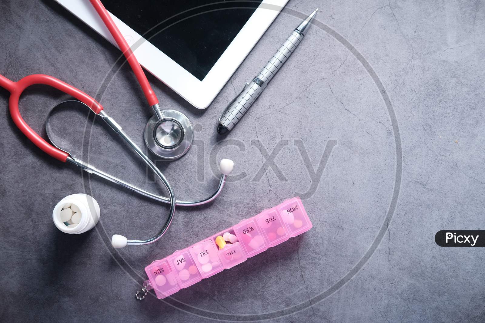 Medical Stethoscope, Pills And Digital Tablet On Black Background