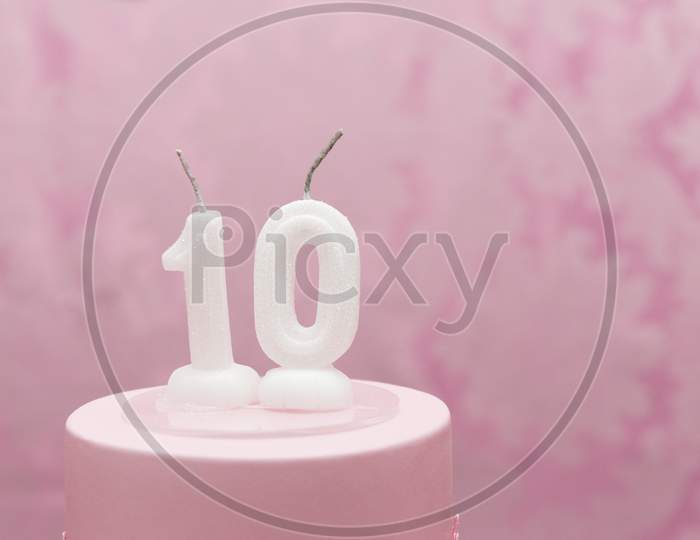 Birthday Cake With Candles As Number Ten On Pink Arabesques Background.